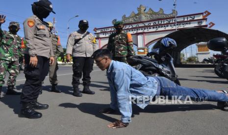 Petugas gabungan Satgas COVID-19 Kota Bandar Lampung memberikan hukuman kepada pengendara motor yang tidak mengenakan masker saat pemeriksaan dan penyekatan kendaraan di Rajabasa, Bandar Lampung, Lampung, Kamis (15/4/2021). Pemeriksaan dan penyekatan kendaraan dilakukan serentak di lima titik pintu masuk Kota Bandar Lampung sebagai upaya meminimalisir penyebaran COVID-19 di Kota Bandar Lampung. 