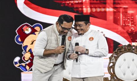 Calon Gubernur DKI Jakarta nomor urut satu Ridwan Kamil (kiri) merangkul cawagubnya Suswono (kanan) saat menyampaikan visi misi pada debat pertama pasangan Calon Gubernur dan Wakil Gubernur DKI Jakarta tahun 2024 di JIExpo Kemayoran, Jakarta, Ahad (6/10/2024). Debat perdana tersebut mengangkat tema penguatan SDM dan transformasi Jakarta menjadi Kota Global. 