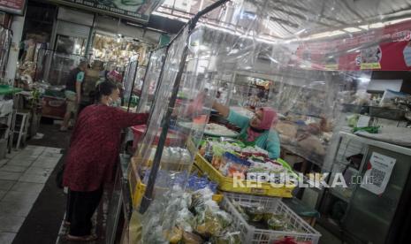 Suasana aktifitas jual beli dengan dibatasi sekat plastik di Pasar Gede, Solo, Jawa Tengah, Senin (11/1/2021). Selama pelaksanaan Pemberlakukan Pembatasan Kegiatan Masyarakat (PPKM) 11-25 Januari 2021 operasional pasar tradisional di Kota Solo tetap buka dengan pembatasan waktu operasional sampai pukul 18:00 WIB dan menerapkan protokol kesehatan ketat. 