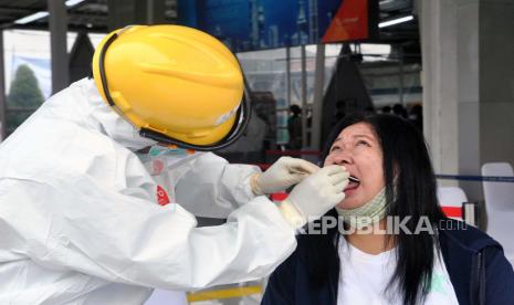 Petugas medis mengambil sampel penumpang KRL Commuter Line saat tes swab di Stasiun Bogor, Jawa Barat, Senin (27/4/2020). Tes massal disebut perlu dilakukan secara cepat dan menyeluruh dengan metode qRT-PCR.  