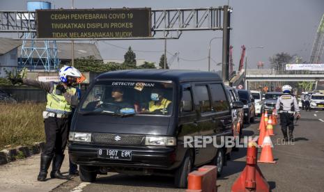 Petugas gabungan memeriksa identitas dan surat keterangan negatif Covid-19 dari pengemudi kendaraan dengan pelat nomor dari luar Bandung di gerbang keluar Tol Cileunyi, Kabupaten Bandung, Senin (26/4). Satlantas Polresta Bandung mencatat sejak 24 April 2021 sebanyak 963 kendaraan putar balikdi Gerbang Tol (GT) Cileunyi, Kabupaten Bandung, Jawa Barat, dalam penyekatan arus mudik Lebaran 2021. . Foto: Republika/Abdan Syakura