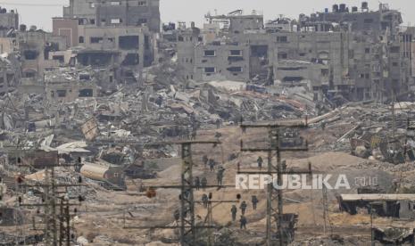 Pasukan Israel berjalan di Jalur Gaza dilihat dari Israel selatan, (21/12/2023).