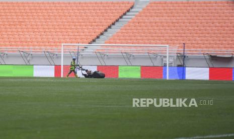 Pekerja memotong rumput lapangan di Jakarta International Stadium, Jakarta, Selasa (12/4/2022). Ajang sepak bola International Youth Championship 2021 (IYC 2021) akan digelar di Jakarta International Stadium pada 13,15,17, dan 19 April yang diikuti oleh empat tim yakni Barcelona U-18, Atletico Madrid U-18, Indonesia All Star U-20, dan Bali United U-18. 