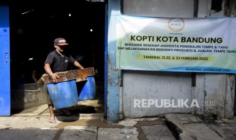 Pekerja membawa wadah tahu saat aksi mogok di salah satu pabrik tahu di Sentra Industri Tahu Cibuntu, Babakan Ciparay, Kota Bandung, Senin (21/2/2022). Seluruh Industri Perajin Tahu di kawasan tersebut melakukan aksi mogok produksi mulai 21 Februari hingga 23 Februari akibat tingginya harga bahan baku kedelai yang mencapai Rp12 ribu per kilogram sehingga mengganggu biaya produksi dan harga penjualan tahu ke masyarakat. Foto: Republika/Abdan Syakura