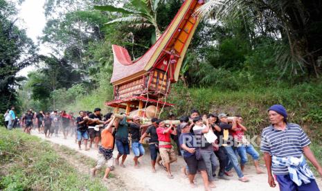 Keluarga duka mengarak jenazah saat prosesi penguburuan pada upacara pemakaman adat Toraja atau Rambu Solo di Sa