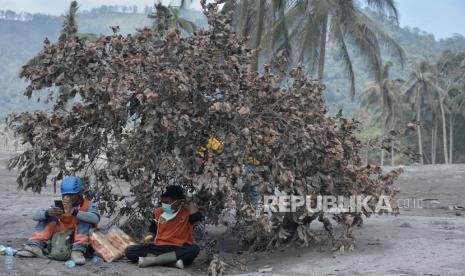 Relawan beristirahat saat melakukan proses evakuasi lanjutan korban yang diduga masih tertimbun longsoran material awan panas di Kampung Renteng, Desa Sumberwuluh, Lumajang, Jawa Timur, Rabu (8/12). Data tim DVI Polri, korban erupsi Gunung Semeru yang ditemukan meninggal hingga Selasa (7/12) berjumlah 30 orang. Dari jumlah itu, 10 jenazah sudah berhasil diidentifikasi. Sementara 20 jenazah lainnya masih dalam proses identifikasi.