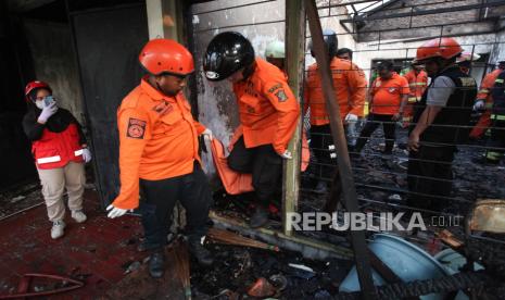 Petugas mengevakuasi jenazah korban kebakaran rumah di Jalan Kertajaya Indah Timur, Surabaya, Jawa Timur, Selasa (14/11/2023). Dinas Pemadam Kebakaran dan Penyelamatan Kota Surabaya mengerahkan sebanyak 14 kendaraan pemadam kebakaran untuk menangani kebakaran rumah yang menewaskan dua orang penghuni.  