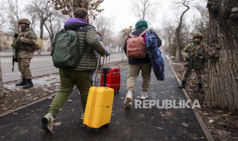 Warga Rusia berjalan menuju bandara untuk menaiki pesawat Angkatan Udara Rusia meninggalkan Kazakhstan menuju Moskow di Almaty, Kazakhstan, Ahad, 9 Januari 2022. 