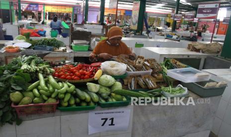 Pedagang menunggui barang jualannya saat penerapan sistem lapak ganjil genap di Pasar Klojen, Malang, Jawa Timur, Kamis (14/5/2020). Penerapan sistem lapak ganjil genap tersebut mulai diberlakukan saat masa Pembatasan Sosial berskala Besar (PSBB) di kawasan Malang Raya yakni Kota Malang, Kota Batu dan Kabupaten Malang sebagai upaya pencegahan penyebaran COVID-19