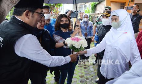 Penyandang disabilitas Raisya Putri Fathimah memberikan bunga kepada Gubernur Jawa Barat Ridwan Kamil (berpeci) saat penyerahan bantuan kemanusiaan Gubernur Jawa Barat untuk Raisya di Jalan Pamoyanan, Cicendo, Kota Bandung. Kegiatan kerja sama antara Pemprov Jawa Barat, Jabar Quick Response dan Rumah Yatim ini merupakan bentuk kepedulian Pemprov Jawa Barat terhadap warga, khususnya yang membutuhkan bantuan. (Ilustrasi)