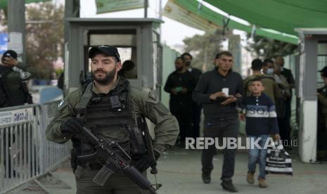  Pasukan Israel Serang Kesucian Masjid Al-Aqsa. Foto:   Seorang petugas Polisi Perbatasan Israel mengamankan sebuah pos pemeriksaan dari kota Betlehem di Tepi Barat ke Yerusalem ketika orang-orang Palestina menyeberang untuk salat Jumat pertama di bulan suci Ramadhan di kompleks masjid Al Aqsa di Kota Tua Yerusalem, Jumat, 8 April 2022.