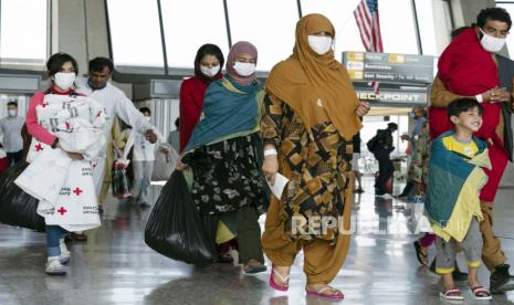 Keluarga dievakuasi dari Kabul, Afghanistan, berjalan melalui terminal sebelum naik bus setelah mereka tiba di Bandara Internasional Washington Dulles, di Chantilly, Va, pada Kamis, 26 Agustus 2021.