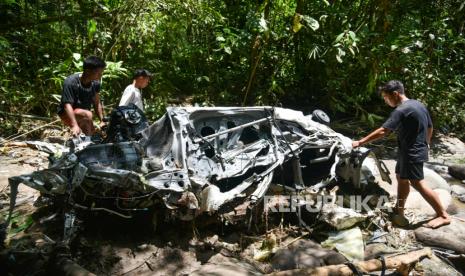 Sejumlah warga mengamati bangkai mobil yang terseret arus banjir bandang di Sembahe, Deli Serdang, Sumatera Utara, Senin (1/5/2023). Berdasarkan data Badan Penanggulangan Bencana Daerah (BPBD) Provinsi Sumatera Utara, banjir bandang yang terjadi pada Minggu 30 April 2023 tersebut mengakibatkan sejumlah fasilitas wisata alam pemandian sungai rusak, dua unit rumah rusak dan satu mobil mini bus terseret arus. 