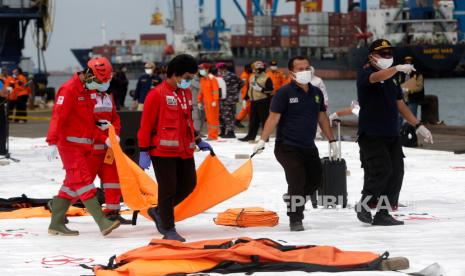 Petugas penyelamat dan Disaster Victim Identification (DVI) Indonesia membawa kantong jenazah di pelabuhan Tanjung Priok di Jakarta, Indonesia, 10 Januari 2021. Kontak ke penerbangan Sriwijaya Air SJ182 hilang pada 09 Januari 2021 tak lama setelah pesawat lepas landas dari Bandara Internasional Jakarta saat dalam perjalanan ke Pontianak di provinsi Kalimantan Barat