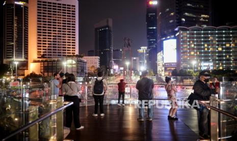 Warga menikmati lanskap perkotaan saat waktu berbuka puasa di anjungan Halte Bundaran Hotel Indonesia, Jakarta, Ahad (2/4/2023). Pemerintah menargetkan pendapatan negara naik 11,08 — 12,38 persen dari produk domestik bruto (PDB) pada tahun depan. 