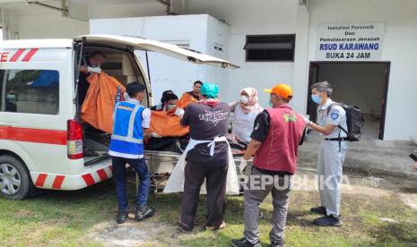 Petugas tengah mengevakuasi korban tewas di kilometer 58 Tol Cikampek, Senin (8/4/2024). Sebanyak 9 orang tewas akibat kecelakaan satu bus dengan dua mini bus. 