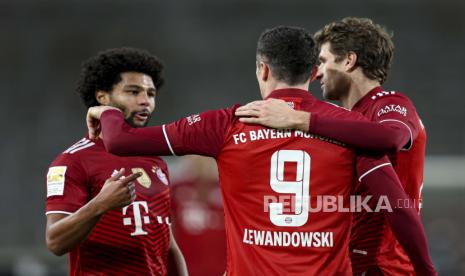 Pemain Munich Robert Lewandowski, tengah, merayakan dengan pemain Munich Thomas Moeller, kanan, dan pemain Munich Serge Gnabry setelah mencetak gol ketiga timnya selama pertandingan sepak bola Bundesliga antara VfB Stuttgart dan Bayern Munich di Mercedes-Benz Arena di Stuttgart, Jerman, Selasa, 14 Desember. , 2021.