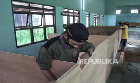 Relawan membuat bilik penyekat di tempat pengungsian Desa Wonokerto, Turi, Sleman, DI Yogyakarta, Selasa (10/11/2020). Posko tanggap darurat Desa Wonokerto menyiapkan barak pengungsian dengan protokol COVID-19 untuk menampung pengungsi di sektor barat lereng Gunung Merapi. 