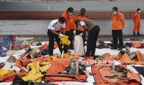 Anggota Badan Pencarian dan Penyelamatan Nasional (BASARNAS) memeriksa puing-puing pesawat Sriwijaya Air penerbangan SJ 182, yang ditemukan dari lokasi kecelakaan di perairan Jakarta, di pelabuhan Tanjung Priok di Jakarta, Indonesia, 19 Januari 2021. Penerbangan Sriwijaya Air SJ182 jatuh ke laut lepas pantai Jakarta pada tanggal 09 Januari 2021 sesaat setelah lepas landas dari Bandara Internasional Jakarta dalam perjalanan ke Pontianak di provinsi Kalimantan Barat.