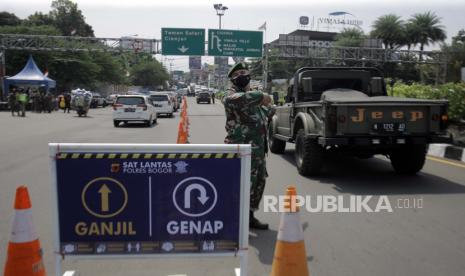 Polisi Berlakukan Ganjil-Genap di Jalur Puncak-Sentul. Anggota TNI  mengarahkan kendaraan saat penerapan sistem ganjil genap di Jalan Raya Puncak, Gadog, Ciawi, Kabupaten Bogor, Jawa Barat, Jumat (3/9/2021). Pemerintah Kabupaten Bogor menerapkan uji coba sistem ganjil genap pada tanggal 3-5 September 2021 bagi kendaraan bermotor di wilayah wisata Puncak. 