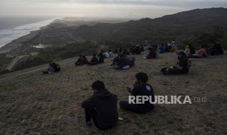 Wisatawan menikmati pemandangan kawasan Pantai Parangtritis dari atas Bukit Paralayang di Purwosari, Gunungkidul, DI Yogyakarta, Jumat (31/7/2020). Sejumlah obyek wisata di kawasan pesisir selatan Yogyakarta dipadati pengunjung terutama wisatawan domestik yang memanfaatkan liburan Idul Adha 1441 H bersama keluarga. 