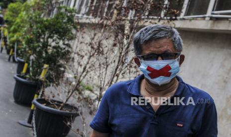 Rocky Gerung memakai masker dengan tanda silang sebagai tanda pembungkaman demokrasi di Mapolda Metro Jaya, Jakarta, Senin (21/3/2022).