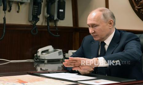 Presiden Rusia Vladimir Putin bertemu dengan Menteri Pertahanan Rusia Sergei Shoigu (tidak dalam gambar) setelah upacara pengibaran panji angkatan laut Rusia di fregat Laksamana Golovko saat kapal ter