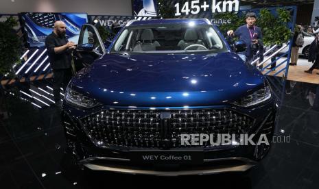 Pengunjung menonton SUV Hybrid plug-in WEY Coffeee 01 oleh pembuat mobil China Great Wall Motors di Paris Car Show Senin, 17 Oktober 2022 di Paris. Eropa memimpin muatan ke kendaraan listrik ketika mobil bertenaga baterai keluar dari ceruk pasar pengadopsi pertama mereka dan memasuki arus utama dengan pangsa pasar yang meningkat yang diperkirakan akan tumbuh kuat ketika UE mendorong untuk menghapus kendaraan mesin pembakaran internal secara bertahap pada tahun 2035