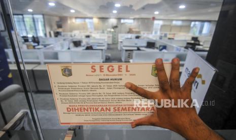 Petugas Dinas Tenaga Kerja, Transmigrasi dan Energi DKI Jakarta saat menyegel salah satu lantai pada gedung perkantoran di Jakarta, Kamis (1/10). Sejak PSBB diberlakukan kembali tercatat sebanyak 77 perusahaan ditutup sementara karena adanya karyawan yang terpapar Covid-19 dan 46 perusahaan ditutup sementara karena tidak menjalankan protokol kesehatan pencegahan Covid-19. Republika/Putra M. Akbar