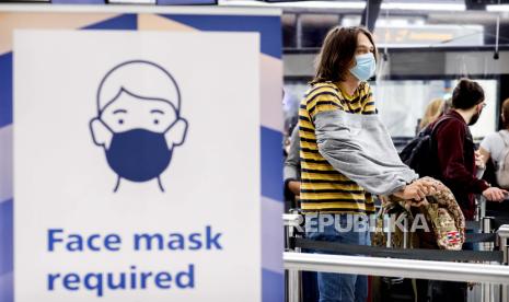 Wisatawan mengenakan masker di Bandara Schiphol, Belanda. Panel penasihat pandemi di Belanda merekomendasikan Eropa barat terapkan pembatasan. Ilustrasi.