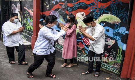 Warga melakukan halal bihalal Idul Fitri 1442 H secara tatap muka di Gang Karya Laksana, Tamansari, Kota Bandung, Kamis (13/5). Sejumlah warga tetap melakukan halal bihalal Idul Fitri 1442 H baik secara tatap muka maupun virtual untuk menjaga tali silaturahmi dengan tetap menerapkan protokol kesehatan guna mencegah penyebaran Covid-19. Foto: Republika/Abdan Syakura