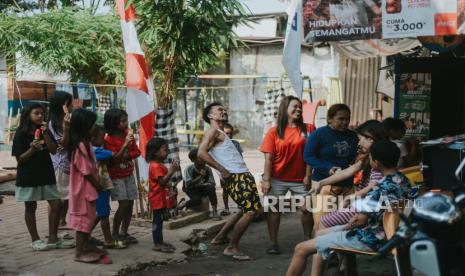 Warga berkumpul saat perlombaan 17 Agustus di Kampung Cahaya atau Kampung Gasong,  Menteng Atas,  Jakarta Pusat, Kamis (17/8/2023). Kampung tersebut merupakan kampung yang dihuni oleh hampir sebagian penduduk berprofesi sebagai pemulung. Mereka hidup dan bertahan di Ibu Kota hasil dari barang-barang pungutan seperti plastik yang kerap ditemukan di tumpukan sampah. Meski demikian,  menurut Mardi, momen perayaan HUT ke-78 Republik Indonesia ia syukuri meski kondisi ekonominya semakin sulit dari hari ke hari. Baginya, Kemerdekaan yang sesungguhnya adalah kesejahteraan yang merata, selama tidak tercapai, artinya Ia dan keluarganya masih harus berjuang meraih kemerdekaan tersebut.