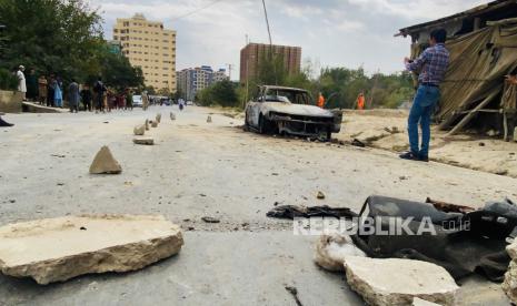  Penduduk setempat berkumpul di dekat kendaraan yang digunakan untuk menembakkan roket di Bandara Internasional Hamid Karzai di Kabul, Afghanistan, 30 Agustus 2021. Beberapa roket yang ditembakkan dari sebuah mobil mendarat di dekat bandara Kabul pada 30 Agustus.