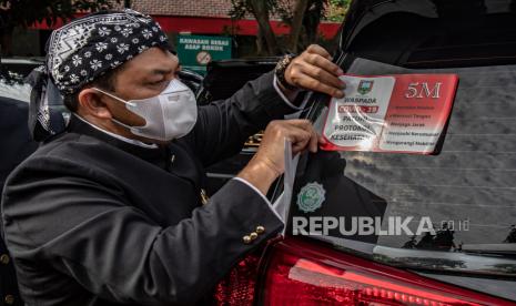 Bupati Semarang Ngesti Nugraha secara simbolis menempelkan stiker himbauan penerapan protokol kesehatan 5M (Memakai Masker, Mencuci Tangan, Menjaga Jarak, Menjauhi Kerumunan, dan Mengurangi Mobilitas) pada mobil dinasnya di Ungaran, Kabupaten Semarang, Jawa Tengah, Senin (15/3/2021). Pemkab Semarang mencanangkan penempelan stiker waspada COVID-19 tersebut pada seluruh mobil dinas Kabupaten Semarang guna mengajak seluruh lapisan masyarakat tetap patuh terhadap protokol kesehatan sebagai upaya mencegah penyebaran COVID-19. 