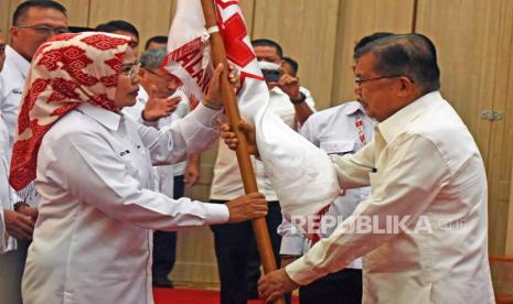 Ketua Umum Palang Merah Indonesia (PMI) Jusuf Kalla (kanan) secara simbolis menyerahkan bendera PMI saat melantik Ketua PMI Banten Ratu Tatu Chasanah (kiri) di Serang, Banten, Rabu (19/10/2022). Jusuf Kalla melantik kepengurusan PMI Banten yang baru masa bakti 2022-2027 menggantikan kepengurusan lama yang telah berakhir masa kerjanya. 