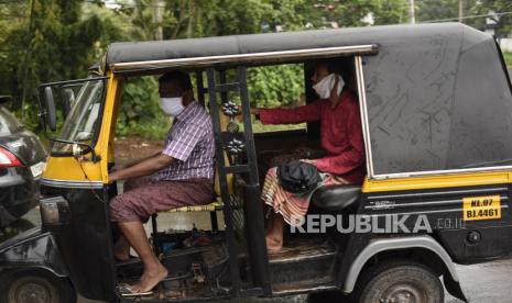 Sejumlah warga mengenakan masker saat menaiki transportasi umum di India. India buka lagi restoran, mal, dan tempat ibadah walau infeksi corona terus bertambah. Ilustrasi.