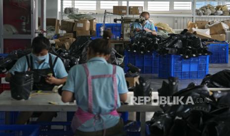  Pekerja mengenakan masker wajah untuk membantu mengekang penyebaran virus corona perakitan sepatu seluncur es di sebuah pabrik manufaktur di taman industri peralatan olahraga es dan salju di Zhangjiakou di provinsi Hebei, China barat laut, Kamis, 15 Juli 2021. 