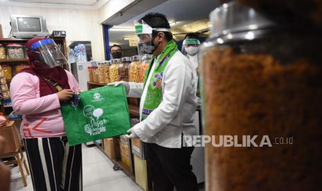 Wakil Gubernur DKI Jakarta Ahmad Riza Patria (kanan) memberikan kantong belanja ramah lingkungan kepada pedagang di Pasar Tebet Barat, Jakarta, Jumat (17/7/2020). Kegiatan tersebut dalam rangka kampanye penggunaan kantong belanja ramah lingkungan guna meminimalisir pemakaian kantong plastik. 