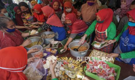 Pedagang membagikan nasi liwet kepada warga saat Syukuran Pedagang sebagai ungkapan syukur dan doa kepada Tuhan YME setelah hasil tes cepat menyatakan bebas Covid-19.