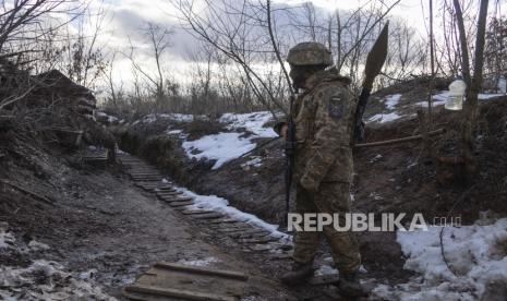 Seorang marinir Ukraina berjalan di parit di garis pemisah dari pemberontak pro-Rusia, wilayah Donetsk, Ukraina, Jumat, 7 Januari 2022. Presiden Ukraina Volodymyr Zelensky mengucapkan terima kasih kepada Amerika Serikat (AS) atas bantuan militer yang diberikan kepada negaranya.