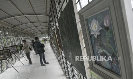 Sejumlah pengunjung mengamati foto yang dipamerkan di gedung creative center Bekasi, Jawa Barat, Selasa (22/2/2022). Pameran yang bertemakan kehidupan kota merupakan rangkaian dari pembukaan gedung creative center Bekasi diikuti 9 Fotografer dan 22 Pelukis berlangsung dari tanggal 21 sampai dengan 27 Februari 2022. 