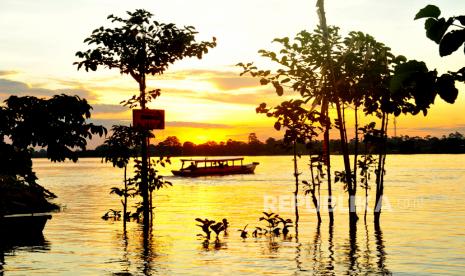 Perahu motor melintasi Sungai Batanghari saat matahari terbenam di Kemingking Dalam, Muarojambi, Jambi, Selasa (21/4/2020). Dinas Kebudayaan dan Pariwisata Provinsi Jambi tengah mengembangkan integrasi wisata antardaerah di wilayah timur provinsi itu yang terhubung dengan jalur Sungai Batanghari meliputi, Kota Jambi, Kabupaten Muarojambi, dan Kabupaten Tanjungjabung Timur dengan konsep wisata alam, sejarah, budaya, dan kuliner