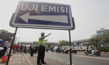 Polisi memberikan pengarahan bagi pengendara yang akan melakukan uji emisi. Kendaraan yang tak lulus uji emisi dilarang masuk kawasan Kantor Wali Kota Jakut.