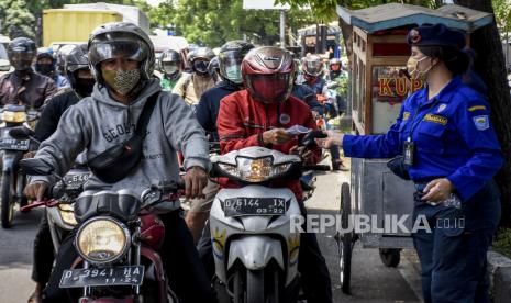 Petugas dari Dinas Kebakaran dan Penanggulangan Bencana (Diskar PB) Kota Bandung membagikan masker kepada warga di Jalan Surapati, Kota Bandung, Senin (28/9). Kegiatan tersebut bertujuan untuk memberikan sosialisasi protokol kesehatan kepada masyarakat sekaligus upaya untuk meminimalisir penyebaran Covid-19 di Kota Bandung. Foto: Abdan Syakura/Republika