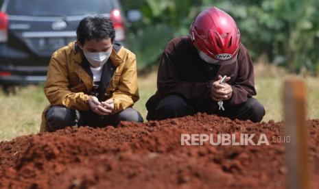 Ilustrasi berdoa di dekat kuburan orang tua.