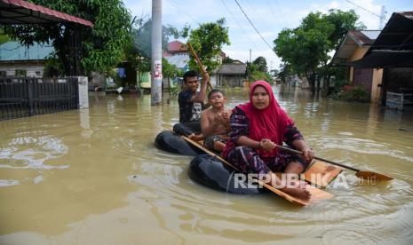 Warga menggunakan ban dalam saat menembus banjir luapan Sungai Belutu dan banjir rob di kawasan Sei Rampah, Serdang Bedagai, Sumatera Utara, Sabtu (13/11/2021). Banjir yang melanda kawasan tersebut sudah terjadi sejak dua pekan terakhir dan telah merendam empat Kecamatan serta diperkirakan sebanyak 5.600 rumah warga terdampak. 