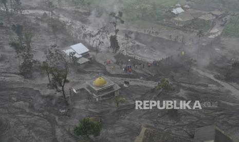  Foto udara yang diambil dengan drone ini menunjukkan penyelamat memeriksa kerusakan di sebuah desa yang terkena dampak letusan Gunung Semeru di Sumberwuluh, Lumajang, Jawa Timur, Indonesia, Senin, 5 Desember 2022. Kondisi cuaca yang membaik Senin memungkinkan penyelamat untuk melanjutkan upaya evakuasi dan pencarian korban setelah gunung berapi tertinggi di pulau terpadat di Indonesia meletus, dipicu oleh hujan monsun.