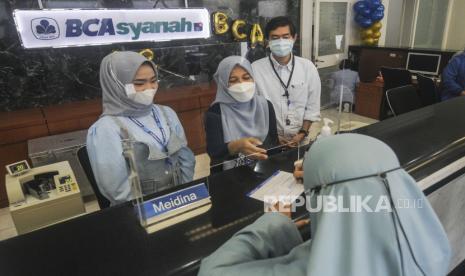 Presiden Direktur BCA Syariah Yuli Melati Suryaningrum (kedua kanan) berbincang dengan nasabah di Kantor Cabang BCA Syariah, Jatinegara, Jakarta, (5/4)/2022). 