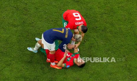 Achraf Hakimi dari Maroko dihibur oleh rekan setimnya Romain Saiss dan Antoine Griezmann dari Prancis setelah pertandingan sepak bola semifinal Piala Dunia antara Prancis dan Maroko di Stadion Al Bayt di Al Khor, Qatar,  Kamis (15/12) dini hari WIB.