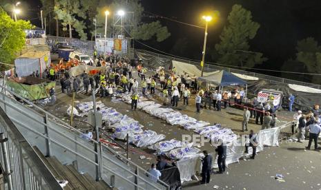 Sejumlah petugas berada di dekat jenazah Yahudi Ultra Ortodoks yang meninggal saat perayaan Lag Baomer di Gunung Meron, Israel, Jumat (30/4). Insiden di festival keagamaan yang dihadiri oleh puluhan ribu orang Yahudi ultra-Ortodoks itu menewaskan puluhan orang dan membuat ratusan orang terluka. Peristiwa tersebut menjadi salah satu bencana sipil paling mematikan di negara itu. )